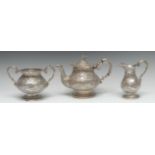 A 19th century Indian silver three piece tea service, in the manner of Oomersi Mawji, Kutch [Cutch},