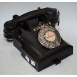 A mid 20th century black Bakelite telephone, call exchange button, label, with number slide to base,