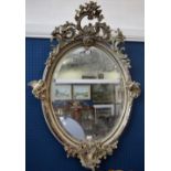 A Rococo style oval wall mirror, gesso moulded,