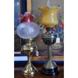 A late 19th/early 20th century oil lamp, brass column and reservoir, opaque glass shade; another,