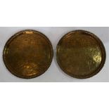 A pair of Indian brass trays, engraved with deities, figures, birds and hounds, floral border,