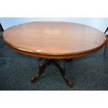 A Victorian mahogany breakfast table, elliptical top inlaid with stylised foliage, turned column,