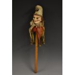 A French composite marotte, as a jester, fixed glass eyes, brass bells, turned wooden handle,