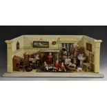 A diorama doll's house, with miniature bisque and other dolls,