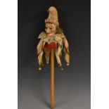 A French composite marotte, as a jester, fixed glass eyes, brass bells, turned wooden handle,