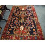 A hand woven Hamadan carpet bold geometric designs in tones of red,