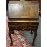 A reproduction lady's bureau cross banded walnut fall front enclosing pigeon holes and drawers,