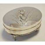 An Edwardian silver casket with hinged cover embossed in relief with irises, William Comyns & Sons,
