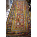 A Middle Eastern hand woven runner, geometric designs in tones of sienna,