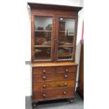 A Victorian mahogany bookcase chest, outswept cornice, two glazed doors enclosing shelving to top,