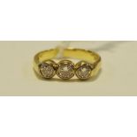 An 18ct gold diamond trilogy ring, rub over setting, approx. 0.5ct total; size L, 3.