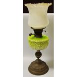 A Victorian Art Nouveau oil lamp, milk glass reservoir in tones of green,