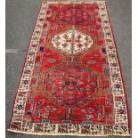 A hand woven Karajeh runner, lozenge shaped motifs in hues of pink,