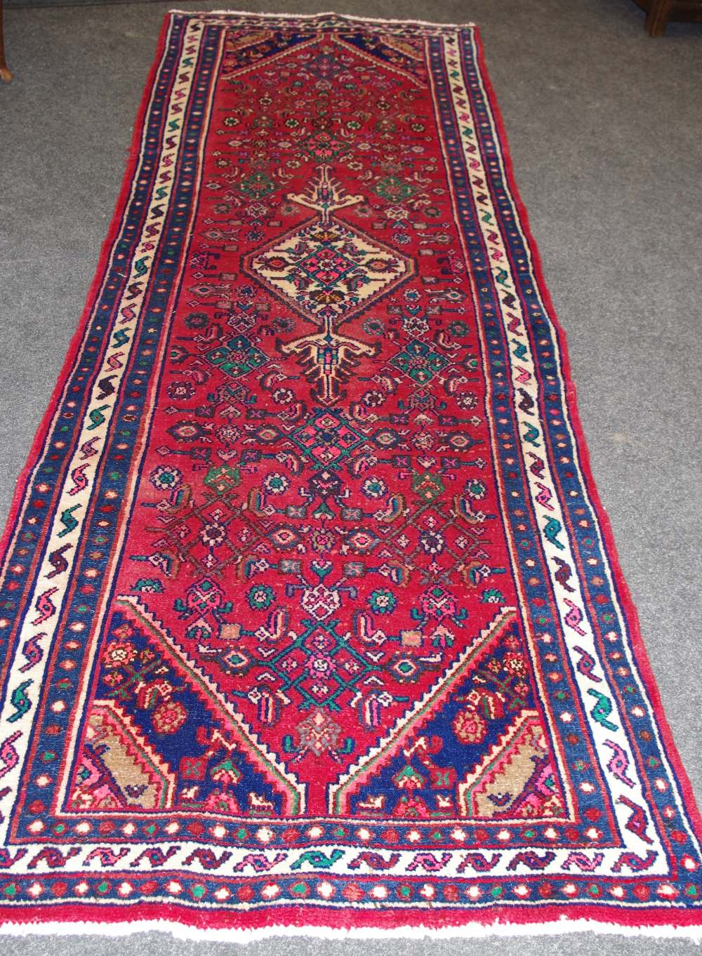 A hand woven Middle Eastern Hamadan runner, geometric designs and floral motifs in hues of green,