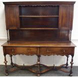 An oak dresser, shelving, cupboards with barley twist supports to top, two drawers to frieze,