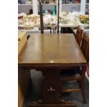 An oak draw leaf dining table; two oak Arts & Crafts dining chairs;
