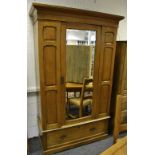 An Edwardian pine wardrobe, outswept cornice, central mirrored door, deep drawer to base,