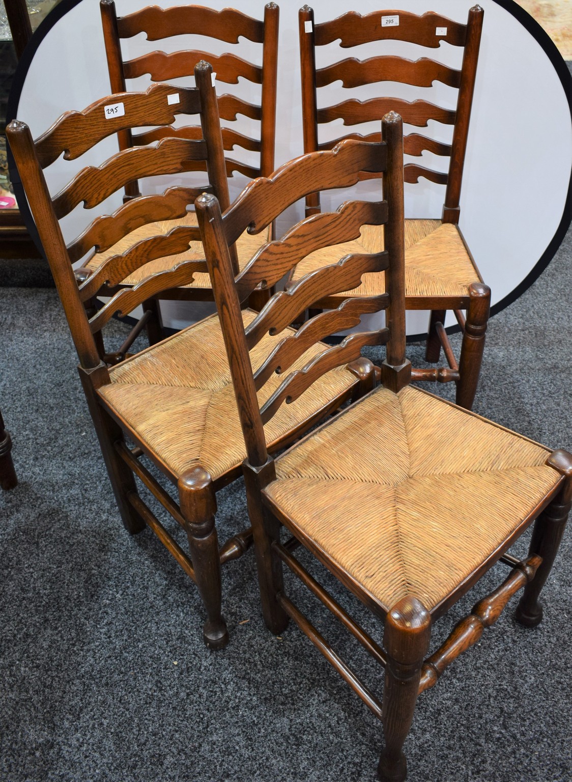 A set of four oak ladder back rush seated dining chairs (4)