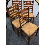 A set of four oak ladder back rush seated dining chairs (4)