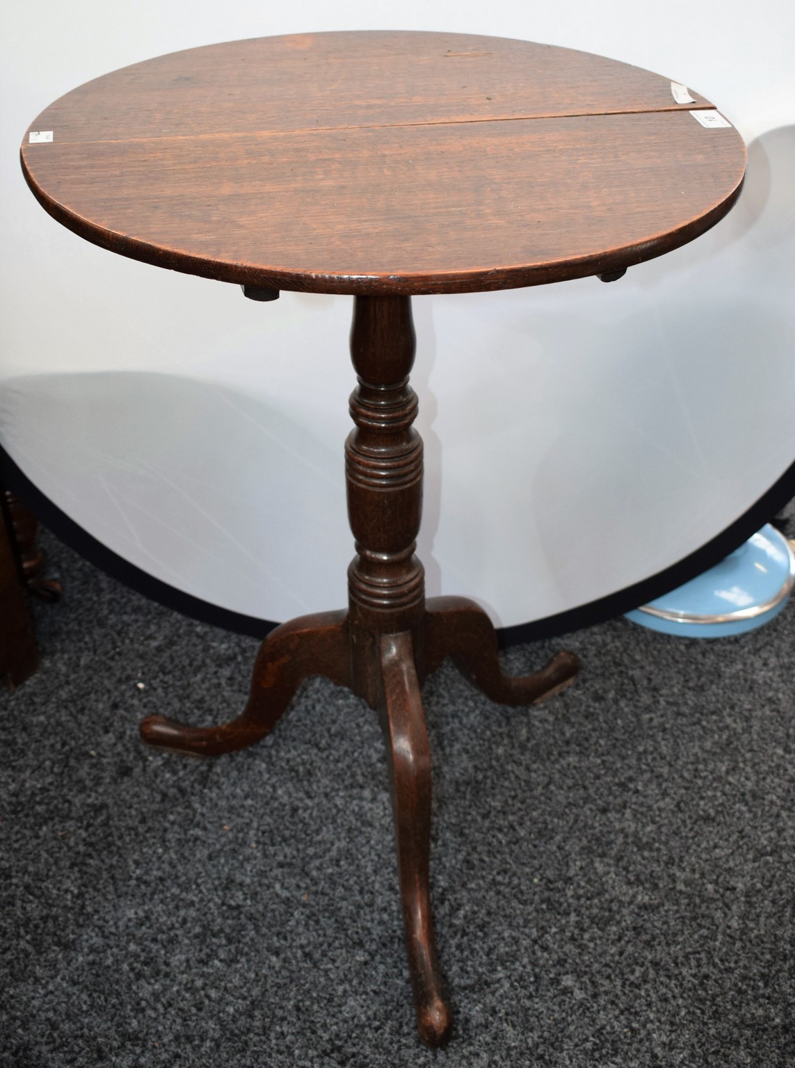 A George III oak tripod occasional table, circular tilting top, ring turned column, triform base,