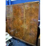 An early-mid 20th century walnut bedroom suite, comprising wardrobe,