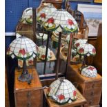 A Tiffany style standard lamp with leaded shade, two similar graduated table lamps,