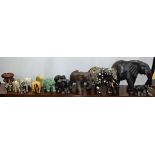 A carved and inlaid figure of an elephant; a carved hardwood elephant; others similar, onyx,