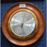 A circular wall barometer thermometer,