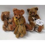 A miniature 1920s golden plush teddy bear, humped back; another,