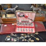 Metalware - a pair of cast metal greyhounds, mounted on teak bases; a leather cutlery box,