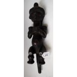 Tribal Art - a Baule spirit spouse figure, modelled seated, holding a vessel,