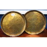 A pair of Indian brass trays, engraved with deities, figures, birds and hounds, floral border,