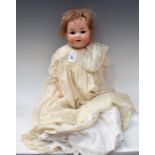 An Armand Marseille 990 socket head doll, sleeping brown eyes, open mouth with two teeth,