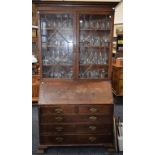 An early 20th century oak bureau bookcase, in the George III taste,