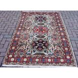 A hand woven Aradabil carpet, geometric motifs in hues of camo-green,