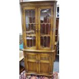 A Reprodux oak floor standing corner cupboard, two lead glazed doors to top,