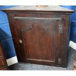 A George III oak corner cupboard, of broad proportions,