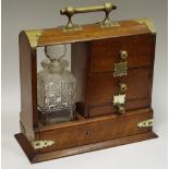 A Victorian oak Tantalus single bottle flanked by a trio of drawers c.