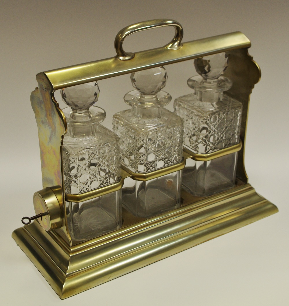 An early 20th century three cut glass bottle brass tantalus,