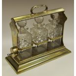 An early 20th century three cut glass bottle brass tantalus,