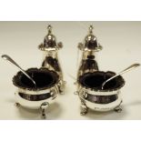 A silver four piece cruet set with blue glass liners and silver spoons,