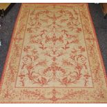 A Laura Ashley rug decorated in red flora on a cafe-au-lait ground.