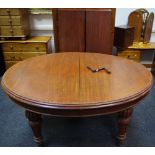 A Victorian mahogany wind out dining table, oval moulded top, deep frieze, turned tapering legs,