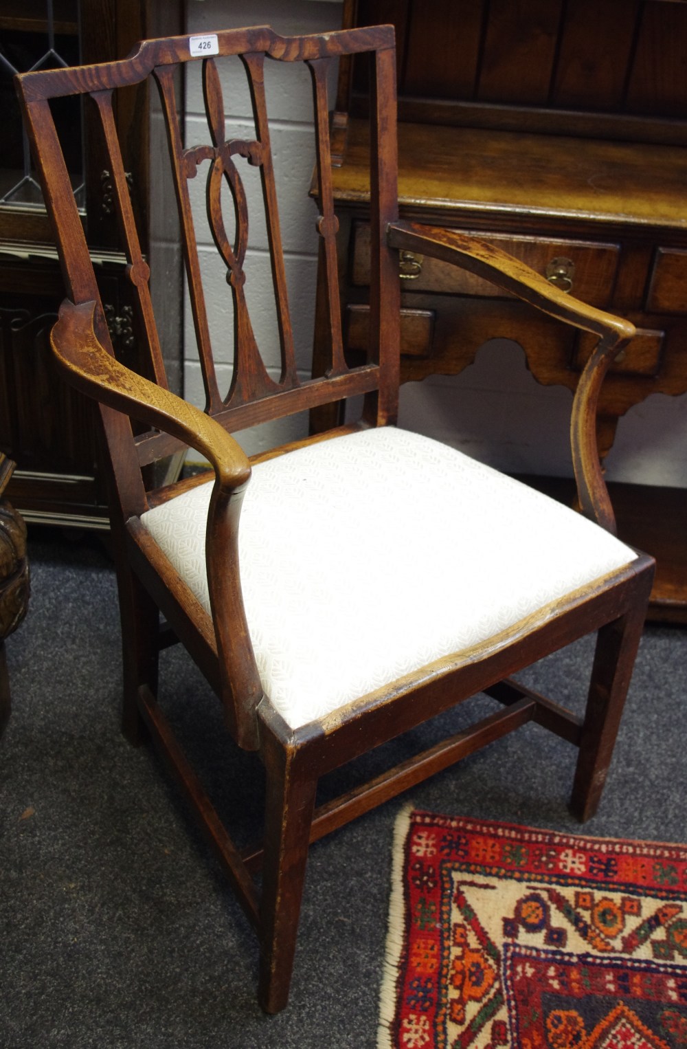 A George III ash and elm armchair, fleur de lys pierced and shaped splat,