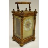 A late 19th century French carriage clock, ornate cast gilt brass case, cream ring dial,