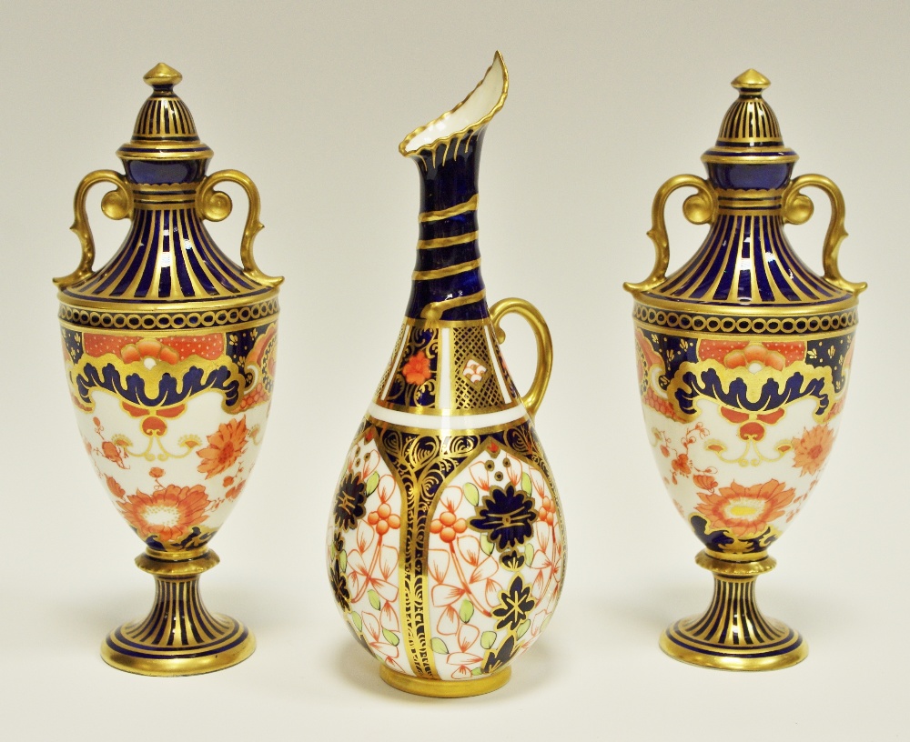 A pair of Royal Crown Derby Imari palette 5590 pattern two handled pedestal vases and covers, 17.