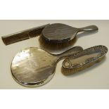 A silver back dressing table set comprising hand brush, mirror, another brush and comb,