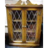 An Old Charm oak wall mounted corner cabinet, shaped pediment, lead glazed doors.