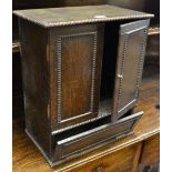 An unusual oak cabinet,hinged cover, two doors over fall front to one side,