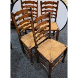 A set of four oak ladder back rush seated dining chairs (4)